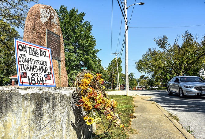 Traffic passes Wednesday by the monument on Moreau Drive that has a sign that reads "On this day the Confederates turned away Oct. 7, 1864" and a wreath marking the anniversary of the event.