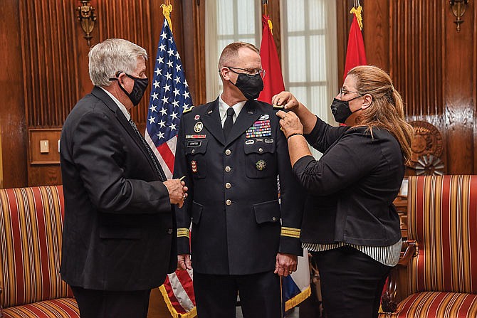 Gov. Mike Parson, left, and Linda Cumpton pin Major General Levon Cumpton with two stars Wednesday during a brief ceremony in the Governor's Office.