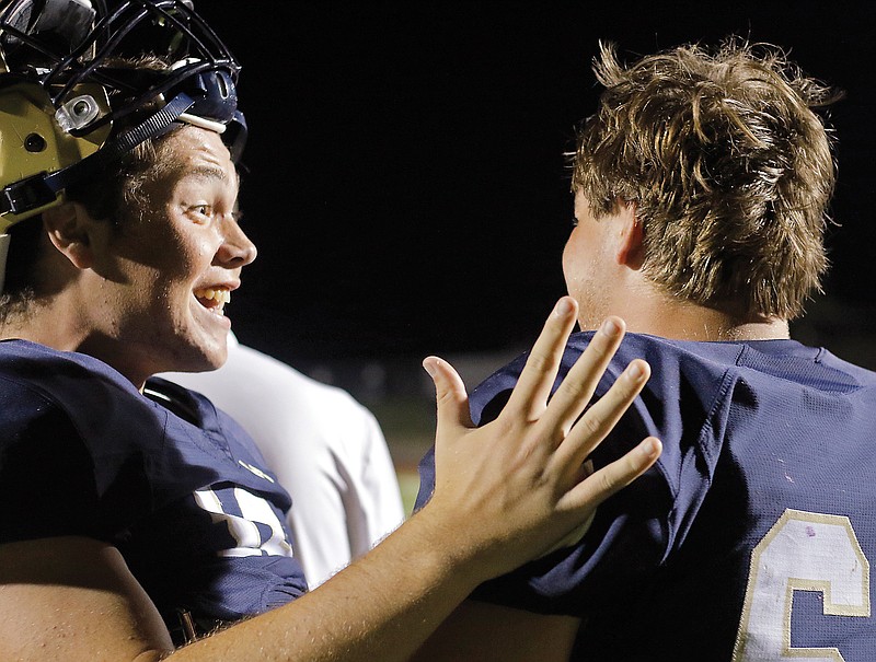 Helias' Zach Wolken (left) talks with teammate Will Heckman after the Crusaders defeated Rock Bridge earlier this season at Ray Hentges Stadium.