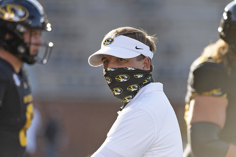 Missouri head coach Eliah Drinkwitz wears a mask while watching his team warm up prior to last month's game against Alabama at Faurot Field.