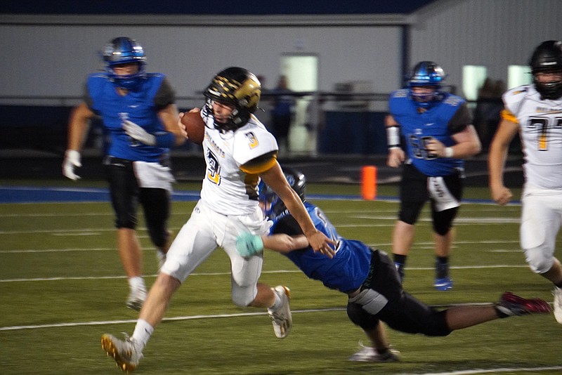 A South Callaway defender tries to take down Cuba senior quarterback Mason Pfeiffer in the Bulldogs' 29-22 win over the Wildcats on Friday night in Mokane