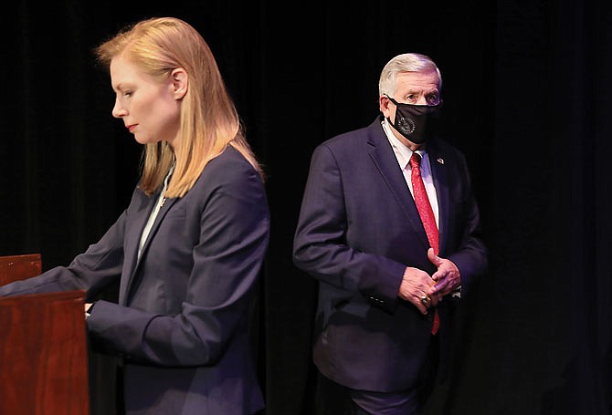 Gov. Mike Parson enters the stage Friday, passing State Auditor Nicole Galloway before the Missouri gubernatorial debate at the Missouri Theatre in Columbia.