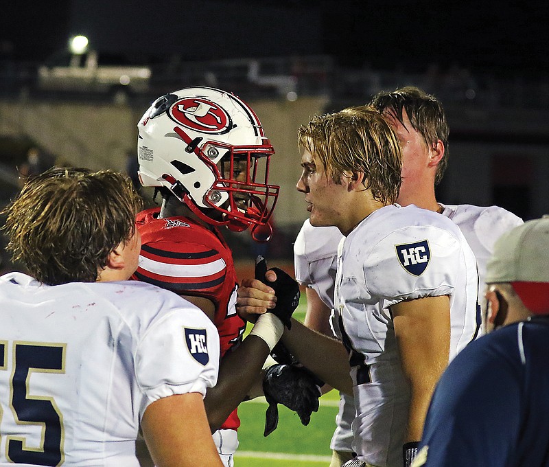Frank Gillmore of Jefferson City and Quinton Baker of Helias shake hands following Friday night's game at Adkins Stadium.