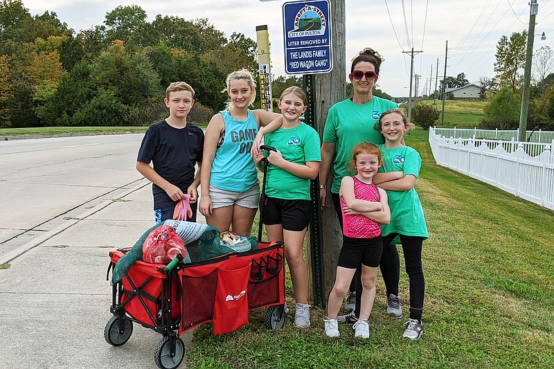 Thursday's crew poses with their haul at the far end of Tennyson Road. It's about a mile each way, and the Landises try to pick up trash on both sides of the road. Sometimes they collect three or four bagfulls in a week, Karli Landis said.