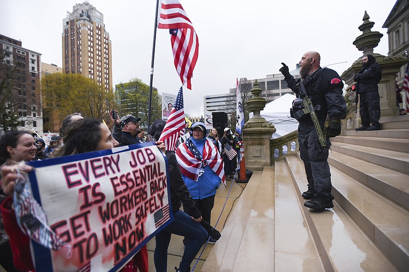 In this April 30, 2020 file photo, protesters rally to denounce Gov. Gretchen Whitmer's stay-home order and business restrictions due to COVID-19, at the state Capitol in Lansing, Mich.  Among the protesters who rallied at the Michigan Capitol against Gov. Gretchen Whitmer’s coronavirus lockdown last spring were armed men now facing charges in a stunning plot to kidnap her. The development has sparked renewed calls for a gun ban in the building and scrutiny of the rallies as potential recruitment events. (Matthew Dae Smith/Lansing State Journal via AP, File)/Lansing State Journal via AP)
