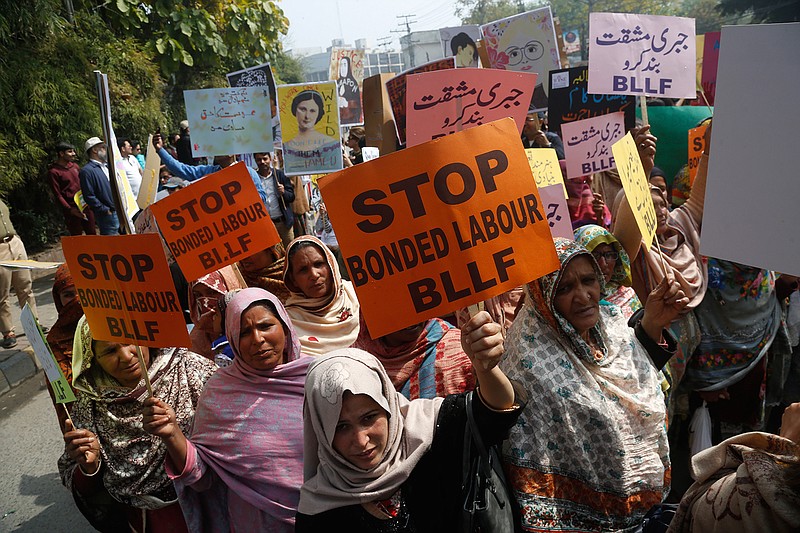 In this March 8, 2020 file photo, Pakistani activists take part in an International Women's Day rally in Lahore, Pakistan.  A new report on Friday, Oct. 9, 2020,  estimates that 29 million women and girls are victims of modern slavery, exploited by practices including forced labor, forced marriage, debt-bondage and domestic servitude.  (AP Photo/K.M. Chaudhry)