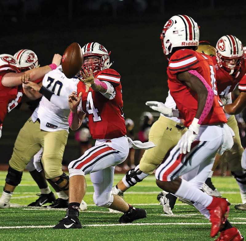 Jefferson City quarterback Seth Brooks pitches the ball to running back David Bethune during Friday night's game against Helias at Adkins Stadium. 