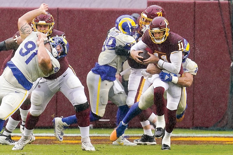 Washington Football Team quarterback Alex Smith is sacked by Troy Reeder of the Rams during Sunday's game in Landover, Md.