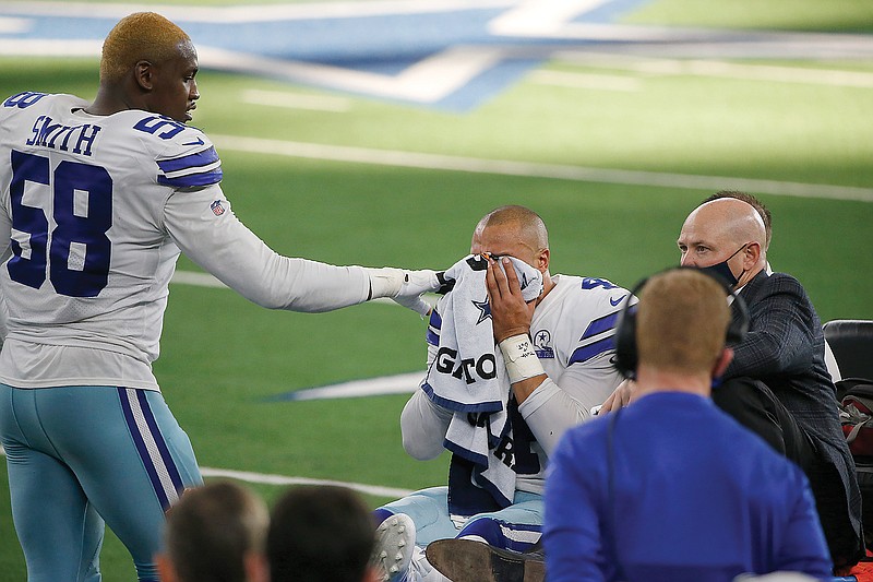 Cowboys defensive end Aldon Smith comforts quarterback Dak Prescott as he is carted off the field after suffering a lower right leg injury during Sunday's game against the Giants in Arlington, Texas.