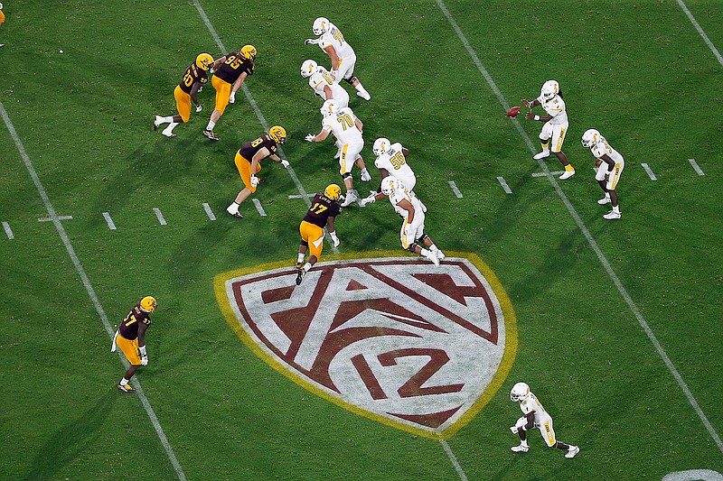 In this Aug. 29, 2019, file photo, is the Pac-12 logo during the second half of an NCAA college football game between Arizona State and Kent State, in Tempe, Ariz. The return of football isn't likely to make much of a dent in the losses athletic departments across the Pac-12 will ultimately incur because of the coronavirus pandemic. Faced with dramatic budget shortfalls, most schools in the league have already resorted to layoffs, furloughs, and cutting some sports entirely. (AP Photo/Ralph Freso, File)