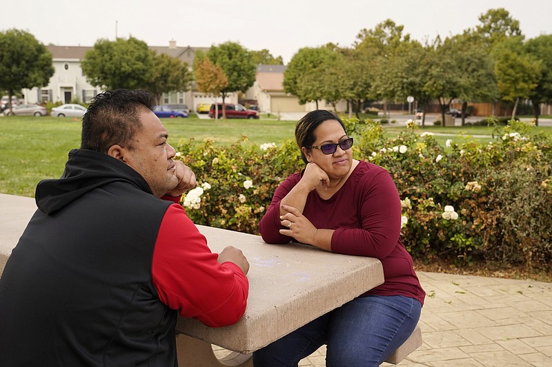 Makerita Iosefo-Va'a and her husband Shaun Va'a sit together in a park near a relative's home where they are temporarily staying in Tracy, Calif., on Oct. 8, 2020. The couple are homesick for American Samoa. She's among an estimated 600 residents of the U.S. territory who were away when American Samoa's governor closed borders to keep the cluster of Pacific islands free from coronavirus. Va?a and others say they don't want American Samoa to open its borders, but just to bring them home safely. (AP Photo/Eric Risberg)