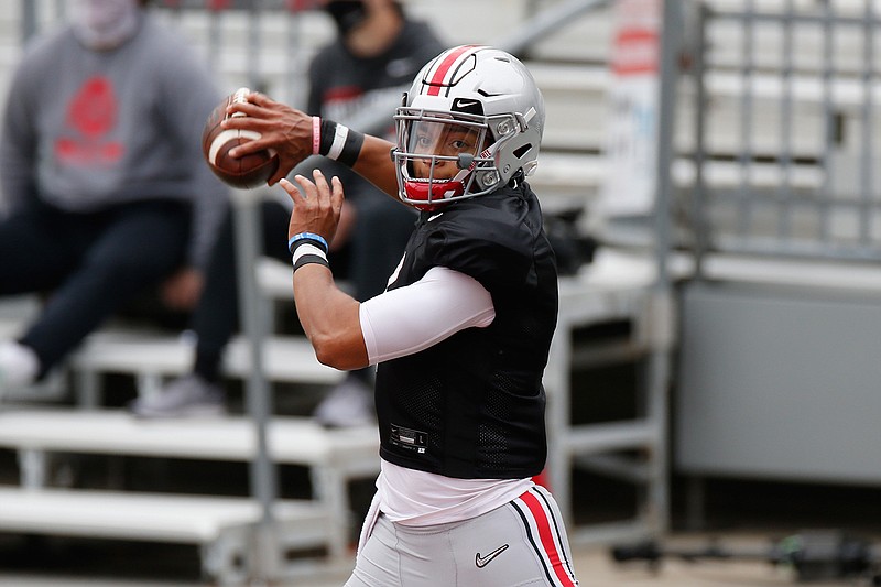 In this Oct. 3, 2020, file photo, Ohio State quarterback Justin Fields throws a pass during their NCAA college football practice in Columbus, Ohio. Fields returns for a second season as Ohio State starter. Coaches and teammates say Fields is in better shape because of diet and workout regimen, and is a more confident and vocal leader. (AP Photo/Jay LaPrete, File)