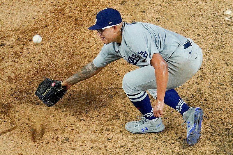 Los Angeles Dodgers starting pitcher Julio Urias can't get a glove on a base hit by Atlanta Braves' Charlie Culberson during the fifth inning in Game 3 of a baseball National League Championship Series Wednesday, Oct. 14, 2020, in Arlington, Texas. (AP Photo/David J. Phillip)