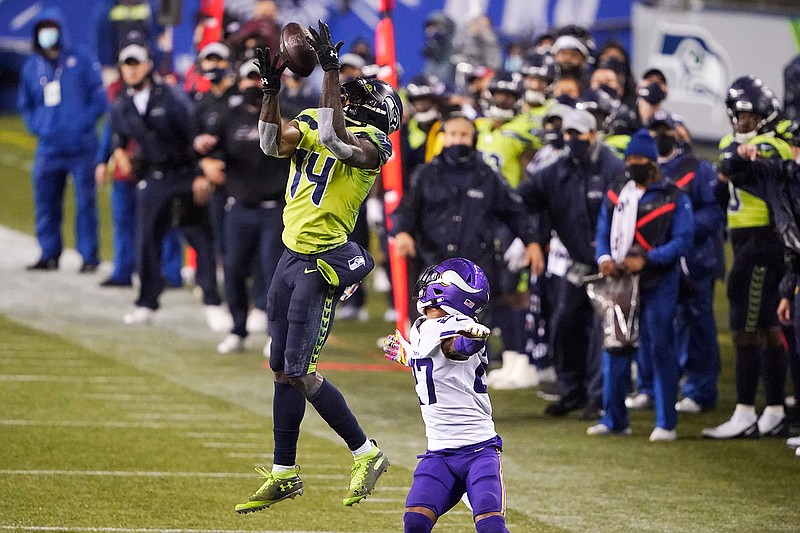 Seattle Seahawks' DK Metcalf (14) pulls in a long pass reception on the Seahawks' last series of an NFL football game as Minnesota Vikings' Cameron Dantzler defends late in the second half, Sunday, Oct. 11, 2020, in Seattle. The Seahawks won 27-26. (AP Photo/Ted S. Warren)