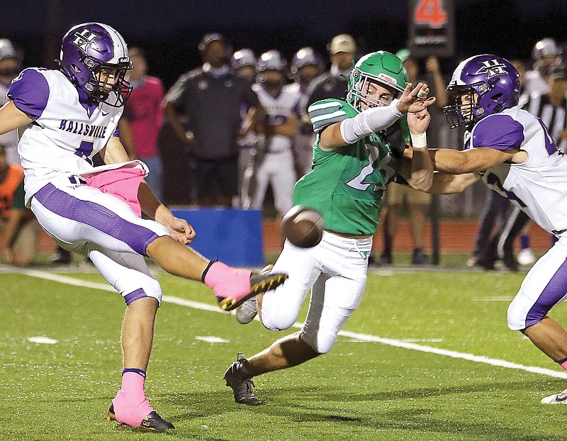 Levi Haney of Blair Oaks reaches to try and block a punt from Hallsville's Tyger Cobb during Friday's Homecoming game at the Falcon Athletic Complex in Wardsville.
