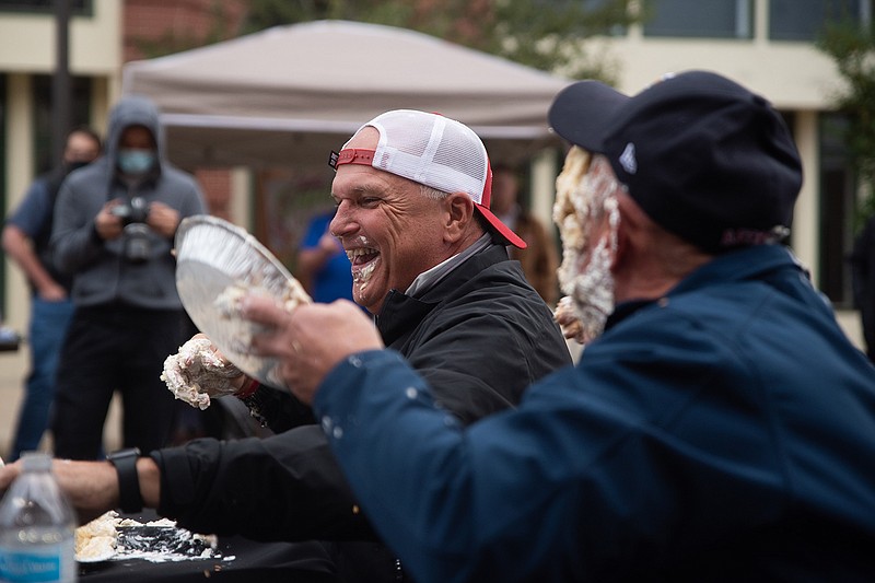 Mayor Bob Bruggeman of Texarkana, Texas, foreground, throws a pie in the face of Arkansas-side Mayor Allen Brown during a friendly game Thursday at the Small Business Expo hosted by the Texarkana Chamber of Commerce on Main Street. The mayors' final task was to eat an entire pie.