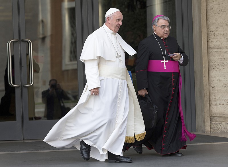 FILE - In this Oct. 5, 2015 file photo, Pope Francis, flanked by bishop Marcello Semeraro, leaves at the end of a morning session of the Synod of bishops, at the Vatican. On Thursday, Oct. 15, 2020 the Vatican announced that Pope Francis nominated Semeraro as Prefect for the Congregation of the Saints. (AP Photo/Alessandra Tarantino, file)