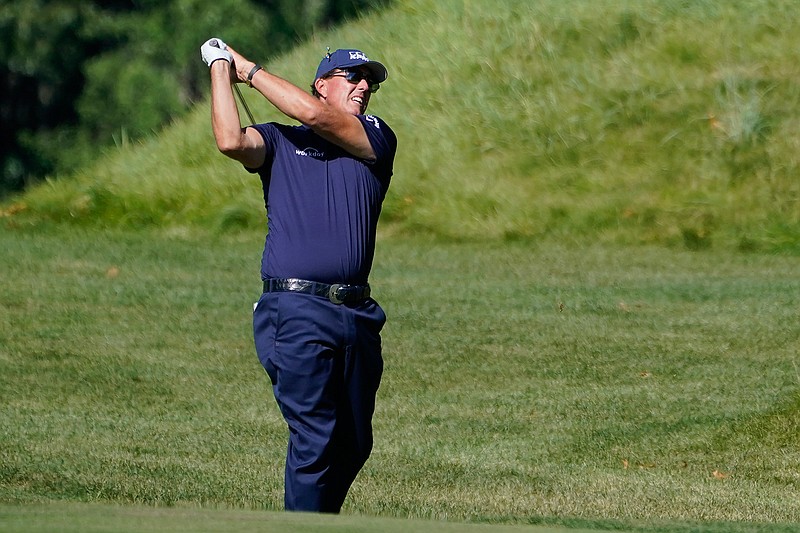 In this Aug. 20, 2020, file photo, Phil Mickelson hits from the rough on the 14th fairway in the first round of the Northern Trust golf tournament at TPC Boston in Norton, Mass. Mickelson will begin his preparation for the Masters in earnest on Friday, Oct. 16, 2020, at a place, and on a tour, not typically associated with the regimen required to win a major. The lefthander is making his second start on the PGA Tour Champions in the Dominion Energy Charity Classic at the Country Club of Virginia's somewhat forgiving James River course. (AP Photo/Charles Krupa, File)