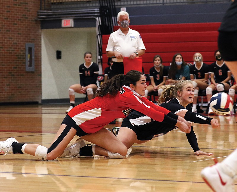 Abigail Blake of Jefferson City dives to the floor alongside libero Sydney Vogt for a dig during Thursday night's match against Hickman at Fleming Fieldhouse.