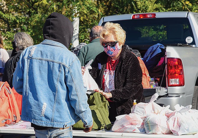 CIndy Leveron, from First Christian Church, hands out backpacks containing hygiene products, socks and other useful items during Friday's Project Homeless Connect at The Salvation Army.