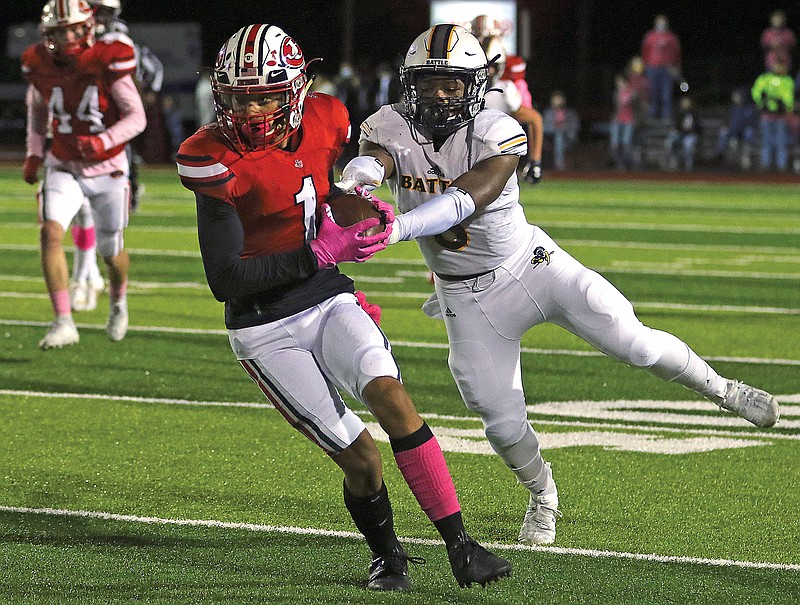 Jefferson City's Marshaun Dye tries to break away from the grasp of Battle's Kendrick Perkins during Friday night's game at Adkins Stadium.