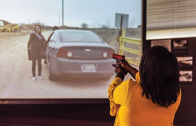 Tom Lane, a freelance journalist from St. Louis, returns simulated fire Friday after the person on the screen drew her weapon to shoot Lane. This was part of a simulation at a Use of Force forum at the Missouri Highway Patrol Headquarters. The agency hosted the event for media partners and featured a hands-on look at MSHP policy surrounding use of force and training.