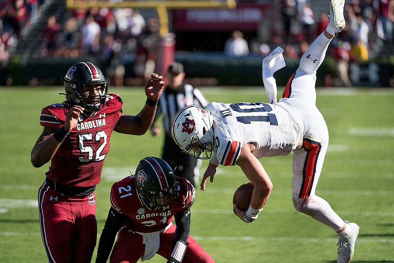 Auburn quarterback Bo Nix (10) is knocked out of bounds by South Carolina defensive back Shilo Sanders (21) and Kingsley Enagbare (52) during the second half of an NCAA college football game Saturday, Oct. 17, 2020, in Columbia, S.C. South Carolina defeated Auburn 30-22. (AP Photo/Sean Rayford)