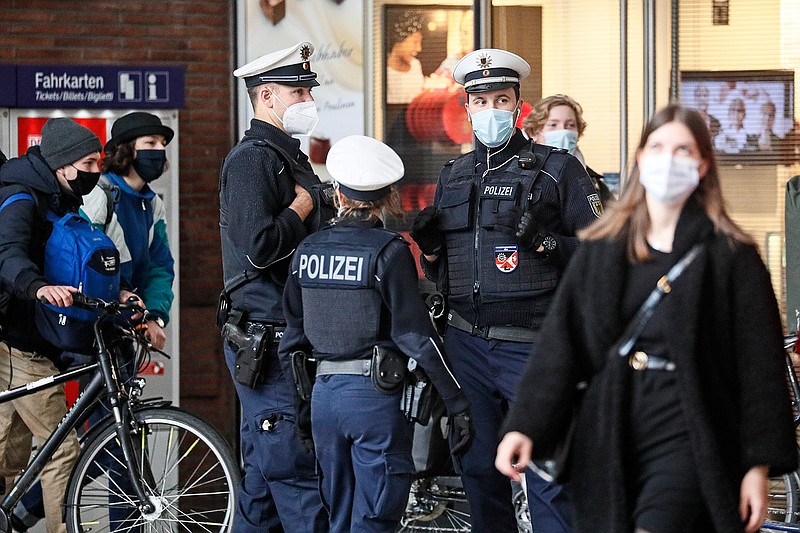 Police with face masks control the coronavirus orders at the train station in Cologne, Germany, Thursday, Oct. 15, 2020. The city exceeded the important warning level of 50 new infections per 100,000 inhabitants in seven days. More and more German cities become official high risk corona hotspots with travel restrictions within Germany. (AP Photo/Martin Meissner)