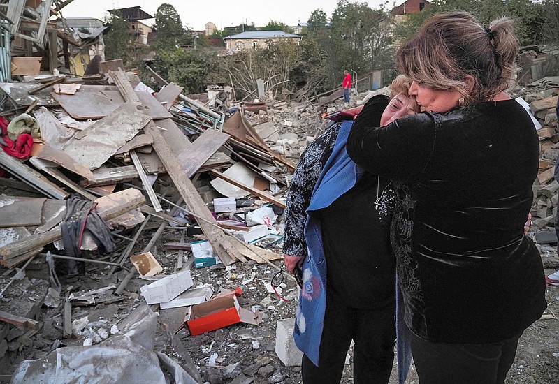 A neighbor comforts home owner, Lida Sarksyan, left, near her house destroyed by shelling from Azerbaijan's artillery during a military conflict in Stepanakert, the separatist region of Nagorno-Karabakh, Saturday, Oct. 17, 2020. The latest outburst of fighting between Azerbaijani and Armenian forces began Sept. 27 and marked the biggest escalation of the decades-old conflict over Nagorno-Karabakh. The region lies in Azerbaijan but has been under control of ethnic Armenian forces backed by Armenia since the end of a separatist war in 1994. (AP Photo)