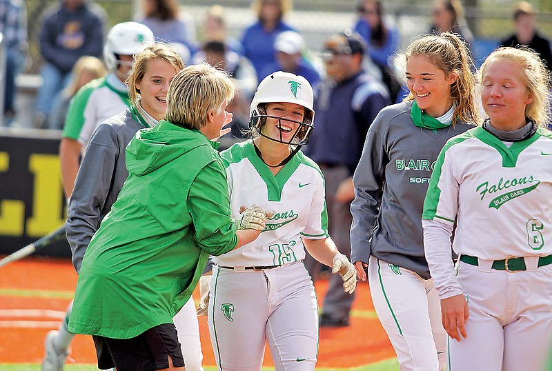 Ellie Kliethermes (center) is congratulated by her coach, Sharon Buschjost, after hitting a solo home run in the bottom of the first inning of Saturday afternoon's Class 3 District 5 Tournament championship game against Fatima at Versailles.