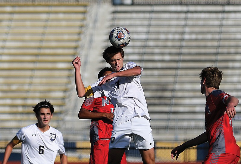 Helias forward Luke Hynes heads the ball to try and control it with pressure from a couple Nixa players during Saturday's game at the Crusader Athletic Complex.