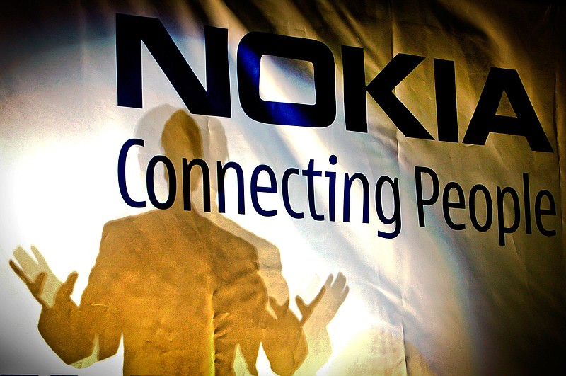 In this Feb. 11, 2008, file picture, general manager of the Nokia factory in Romania, John Guerry, casts a shadow on a banner at the new Nokia factory in Jucu, central Romania, during the official opening of the first production line. Nokia says it has been tapped by NASA to build the first cellular communications network on the Moon. The Finnish technology giant said Monday, Oct. 19, 2020 its Nokia Bell Labs' division will build a 4G communications system to be deployed on a lunar lander to the Moon's surface in late 2022. 