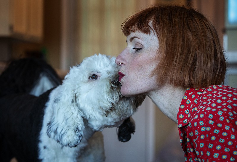 Bunny, a 14-month old sheepadoodle, and her owner Alexis Devine, share a kiss in their Tacoma home Tuesday, Sept. 29, 2020. Devine, an artist in Tacoma, is teaching her dog Bunny to communicate with buttons. (Ellen M. Banner/The Seattle Times/TNS)