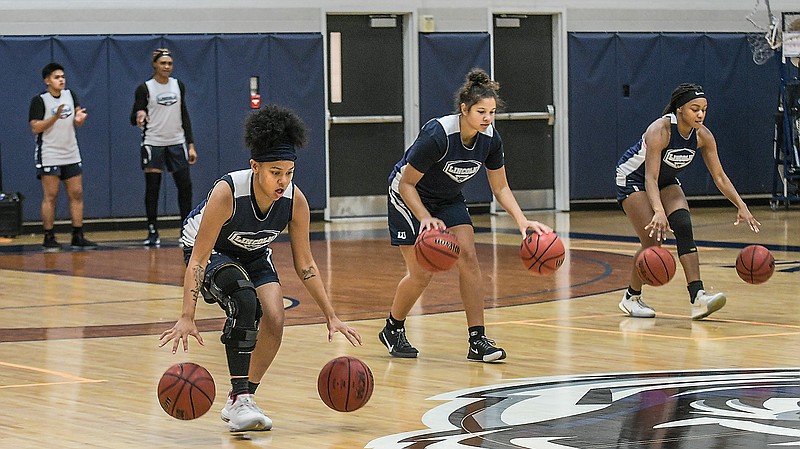 (From left) Lincoln women's basketball players Haylie Holloway, Aliyah Bello and Kiara Cadore run ball handling drills during practice Monday at Jason Gym.