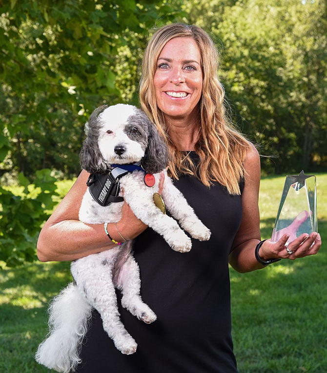 Olive is seen here with her handler, Lisa Bax, who cares for Olive who works with young children through CASA. Olive became the nation's top therapy dog in 2020 and 6 competed with six other dogs for the overall title.