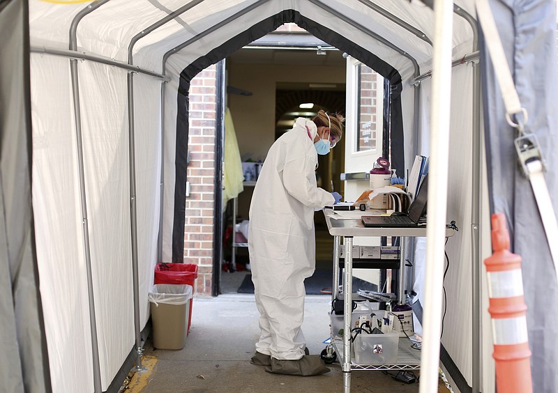 Medical Assistant Casey Garrison inputs patient information on a form at the drive-thru coronavirus testing at a respiratory clinic in Casper, Wyo., Friday, Oct. 9, 2020. Wyoming health officials reported the number of people hospitalized with the virus has increased to the highest since March.(Cayla Nimmo/The Casper Star-Tribune via AP)