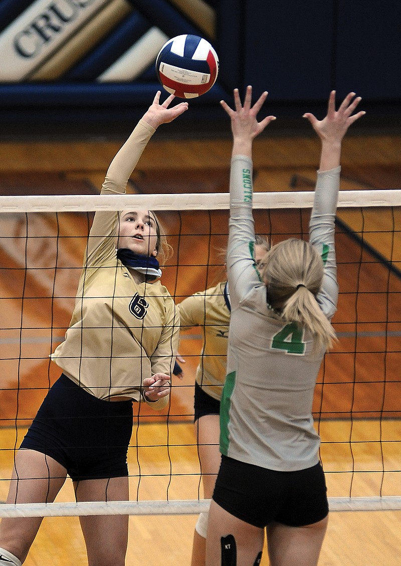 Sydney Mingucci of Helias taps the ball over the net as Alyssa Hargus of Blair Oaks attempts a block during Wednesday night's match at Rackers Fieldhouse.