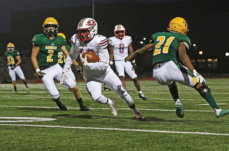 Jefferson City's Kevion Pendelton runs between Rock Bridge teammates Nate Norris (left) and Marquis McCaster during a game earlier this season in Columbia. 
