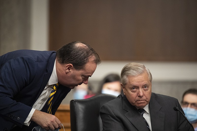 Sen. Mike Lee, R-Utah, left, speaks with Chairman Lindsey Graham, R-S.C., during a Senate Judiciary Committee Executive Business meeting, including the nomination of Amy Coney Barrett to serve as an associate justice on the Supreme Court of the United States, Thursday, Oct. 22, 2020, on Capitol Hill in Washington. (Caroline Brehman/Pool via AP)