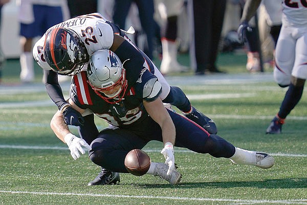 Patriots tight end Ryan Izzo fumbles as Broncos cornerback Michael Ojemudia tackles him last Sunday in Foxborough, Mass.