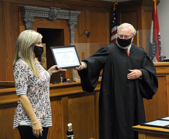 Judge Jon Beetem, right, hands a diploma Thursday to Jennifer Carrol, a graduate of the CASA program, at a special ceremony held in the Cole County Courthouse. 