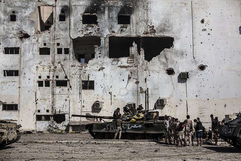 FILE -- In this Sept. 22, 2016 file photo, fighters of the Libyan forces affiliated to the Tripoli government rest and reload weapons during an offensive against Islamic State militants, in Sirte, Libya. The United Nations said Friday, Oct. 23, 2020, that the two sides in Libyan military talks had reached a "historic achievement" with a permanent cease-fire agreement across the war-torn North African country. (AP Photo/Manu Brabo, File)