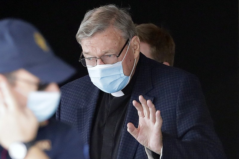 FILE - In this Sept. 30, 2020, file photo, Australian Cardinal George Pell waves as he arrives at Rome's international airport in Fiumicino. Australian state police said Friday, Oct. 23, 2020 it was not investigating the transfer of money from the Vatican to Australia, throwing doubt on Italian media speculation that it might be linked to the overturned convictions of Cardinal George Pell for child sex abuse. (AP Photo/Andrew Medichini, File)