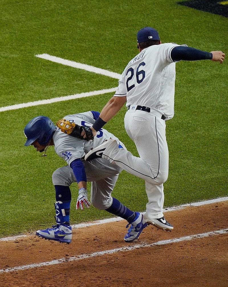Tampa Bay Rays first baseman Ji-Man Choi tags out Los Angeles Dodgers' Mookie Betts at first base during the eighth inning in Game 3 of the baseball World Series Friday, Oct. 23, 2020, in Arlington, Texas. (AP Photo/Sue Ogrocki)