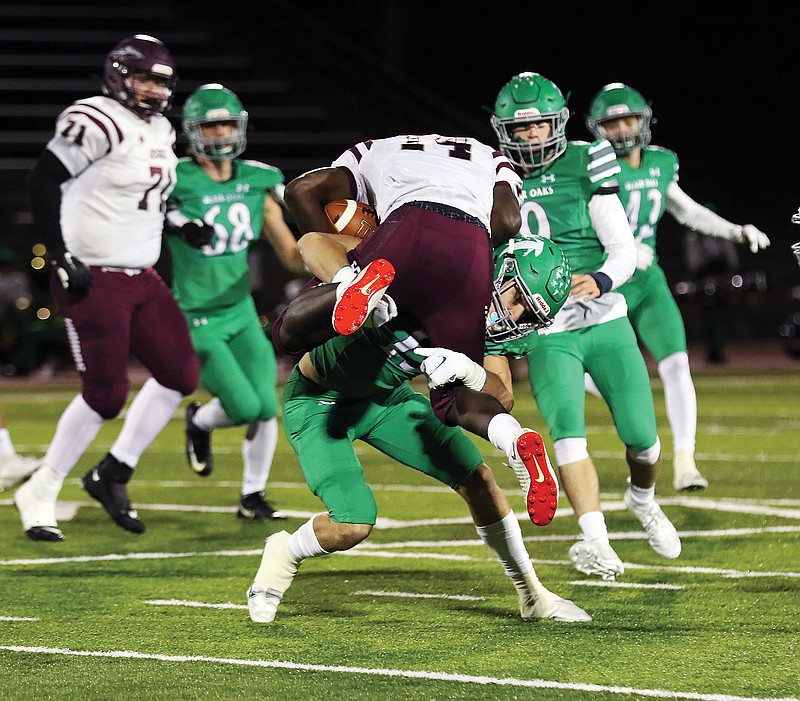 Carson Prenger of Blair Oaks lifts School of the Osage running back Eric Hood off the ground while making a tackle during Friday night's game at the Falcon Athletic Complex in Wardsville.