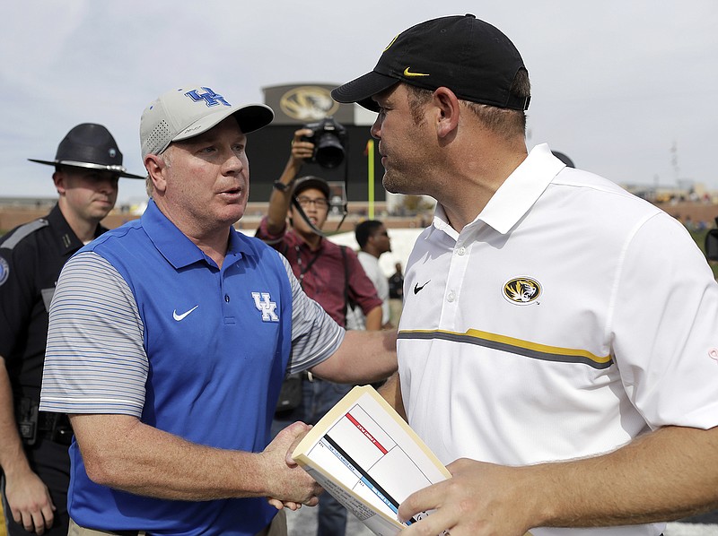 In this Oct. 29, 2016, file photo, Kentucky head coach Mark Stoops and Missouri head coach Barry Odom shake hands following a football game in Columbia.