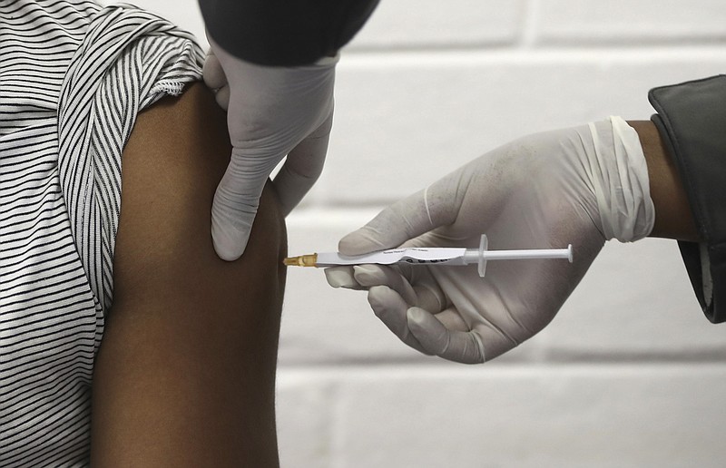 FILE - In this Wednesday, June 24, 2020 file photo, a volunteer receives an injection at the Chris Hani Baragwanath hospital in Soweto, Johannesburg, as part of Africa's first participation in a COVID-19 vaccine trial developed at the University of Oxford in Britain in conjunction with the pharmaceutical company AstraZeneca. On Friday, Oct. 23, 2020, AstraZeneca Inc. announced that the Food and Drug Administration is letting it resume testing of its COVID-19 vaccine candidate in the U.S. (Siphiwe Sibeko/Pool via AP)