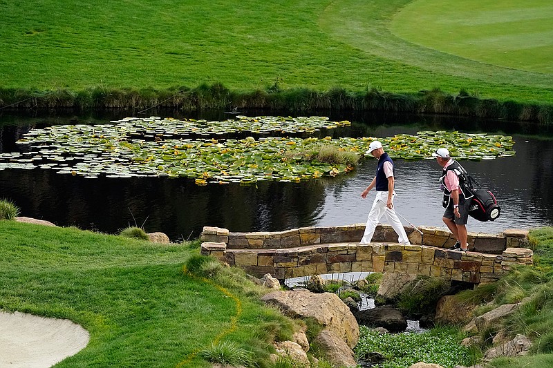 Justin Thomas, left, walks with his caddie to the 18th green during the third round of the Zozo Championship golf tournament Saturday, Oct. 24, 2020, in Thousand Oaks, Calif. (AP Photo/Marcio Jose Sanchez)