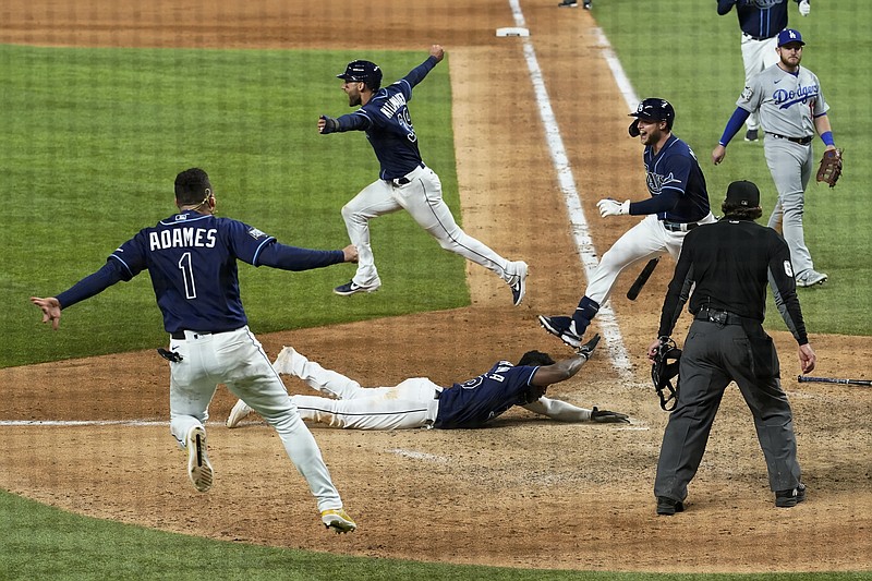 Randy Arozarena (center) of the Rays scores the winning run Saturday in Game 4 of the World Series in Arlington, Texas. The Rays defeated the Dodgers 8-7 to tie the series at 2.