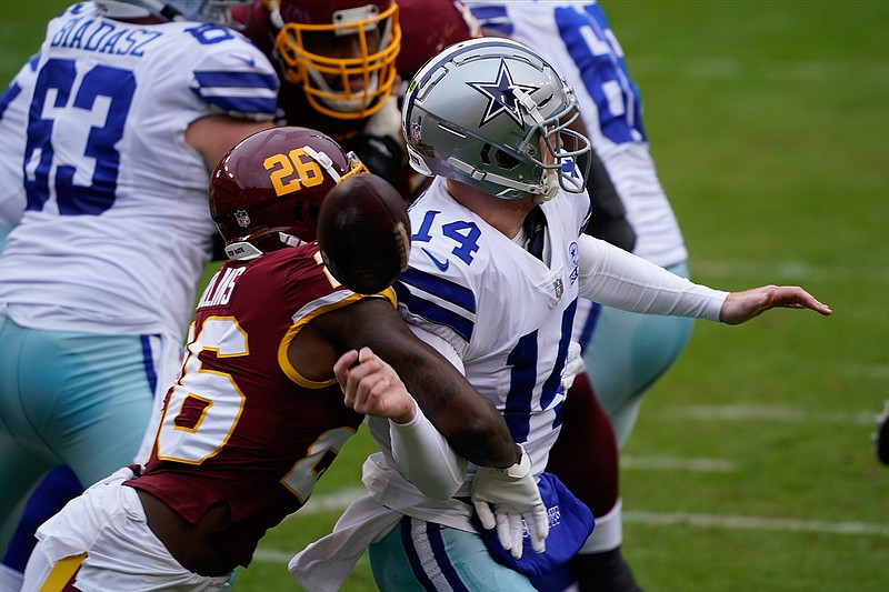 Washington strong safety Landon Collins (26) knocks the ball of the hands of Dallas Cowboys quarterback Andy Dalton (14) during the first half of an NFL football game, Sunday, Oct. 25, 2020, in Landover, Md. (AP Photo/Susan Walsh)
